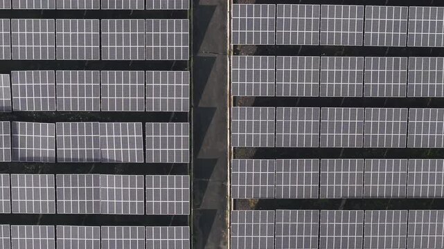 Aerial view of the PLTS 1MWp Bangli solar power plant featuring rows of photovoltaic panels arranged in a grid pattern in Bangli, Bali, Indonesia.