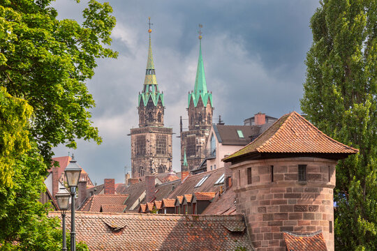 Twin towers of St. Sebald Church rise above traditional rooftops and historic architecture in Nuremberg, Germany.