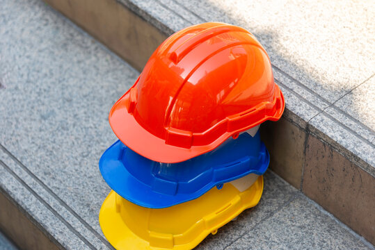 Orange blue white and yellow helmets safety diversity engineering concept