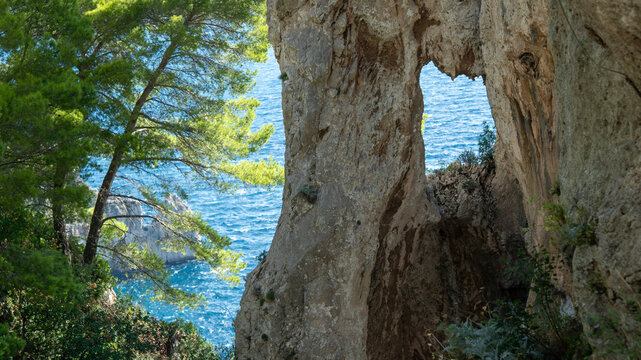 Eroded windows in a natural stone arch overlooking the Mediterranean Sea on the isle of Capri in Italy