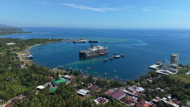 Aerial view of the Cinta Natomas Floating Storage and Offloading ship anchored in the coastal waters near lush tropical greenery in Buleleng Regency, Bali, Indonesia.