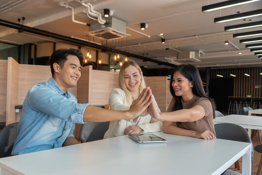 Group of powerful diversity creative people high five on air to greeting power of team. Multiethnic businesspeople working together. Collaboration in Business Team success. StrongTeamwork concept.