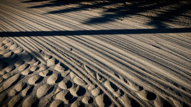 Intricate geometric patterns formed by wind-swept sand dunes and shadows