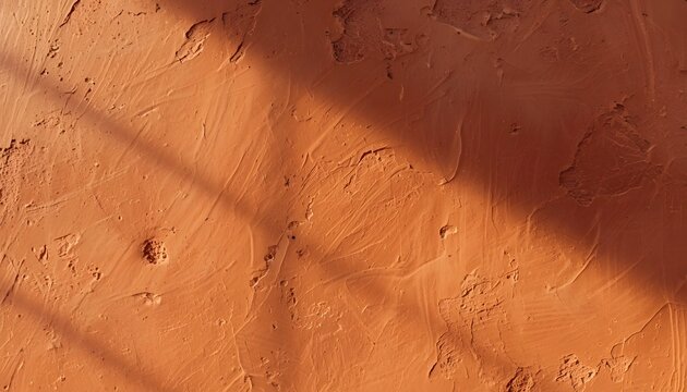 Close-up of hand-troweled terracotta plaster wall with warm rustic texture and natural imperfections