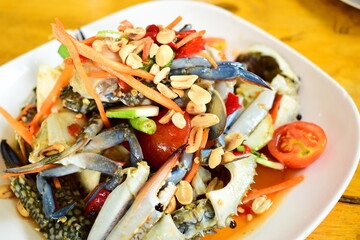 Thai spicy raw blue crab salad serve on a white plate, traditional Thai seafood cuisine © sutichak