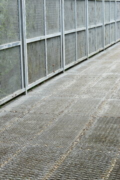 steel mesh canopy walk bridge walkway extending into green jungle
