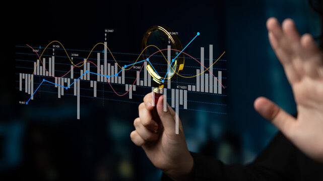 A person using a magnifying glass to analyze stock market data on a digital display, highlighting financial research, trends, and investment opportunities in a modern office setting. Ledger