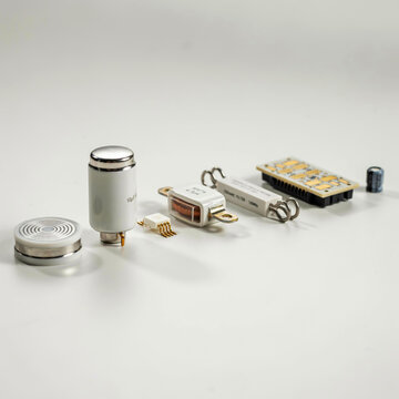 Collection of electronic components and electrical parts including capacitors, resistors, and integrated circuits arranged on a white surface