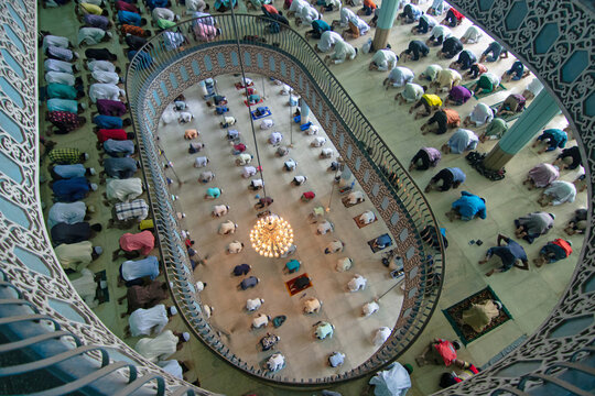 Dhaka, Bangladesh - 21 August 2020: Aerial view of Baitul Mukarram National Mosque with many people praying in rows on the floor, seen from a high angle balcony.