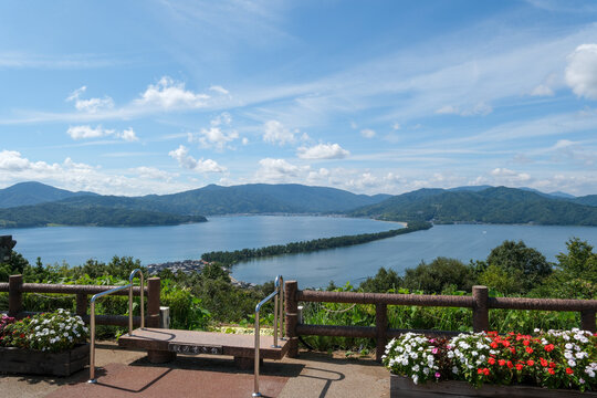 View of Amanohashidate and Aso Sea from Kasamatsu Park observation deck with flower bed and bench in Kyoto Japan