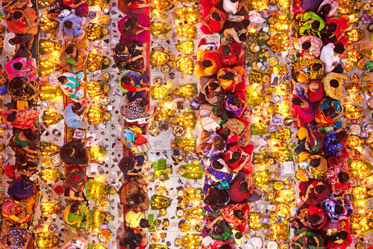 Dhaka, Bangladesh - 09 November 2021: Aerial view of Hindu devotees at the Rakher Upobash festival in Swamibag Loknath Temple, surrounded by glowing oil lamps and ritual offerings.