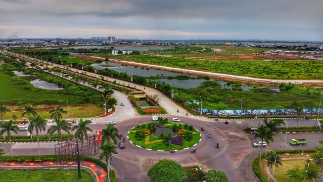 Kecamatan Cakung, Daerah Khusus Ibukota, Indonesia - 11 January 2021: Aerial view of Jakarta Garden City featuring a roundabout, surrounding roads, and green fields.