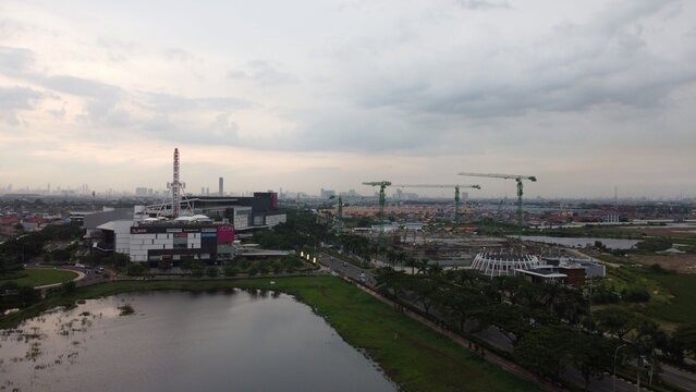 Kecamatan Cakung, Indonesia - 11 January 2021: Aerial view of Jakarta Garden City featuring AEON Mall, construction cranes, a lake, and urban development.