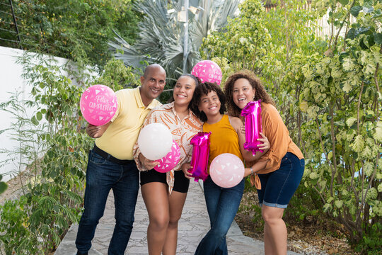 Happy family celebrating birthday party with pink balloons
