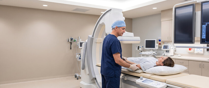 Radiology technician positions adult patient for diagnostic imaging, aligning equipment during hospital procedure to support accurate diagnostics, medical technology and patient care.
