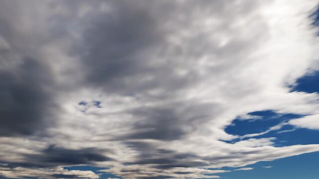 Timelapse of White Clouds Moving Fast Across Clear Blue Sky Background