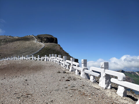 Rocky hiking trail in the mountains Paektu under a bright blue sky
