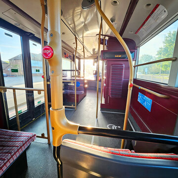 Interior of a London city bus on public transport, showing passenger seating, handrails, and the interior layout of a modern urban bus.