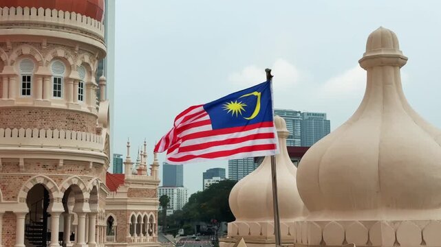 Close up of Malaysian Flag waving near Sultan Abdul Samad Building Moorish Domes at Merdeka square