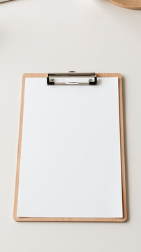 Blank Clipboard on Desk: An empty clipboard with a blank white sheet of paper rests on a clean desk, ready for notes, lists, or ideas.