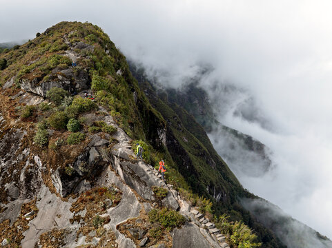 Hiker on a fog-covered rocky mountain ridge in Vietnam