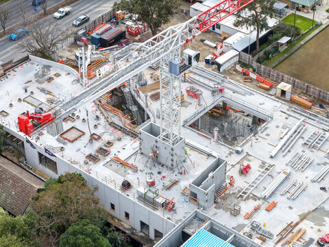 Melbourne, Australia - 24 August 2026: Aerial view of a construction site in Croydon featuring a large tower crane, concrete structures, building materials, and workers on the ground.
