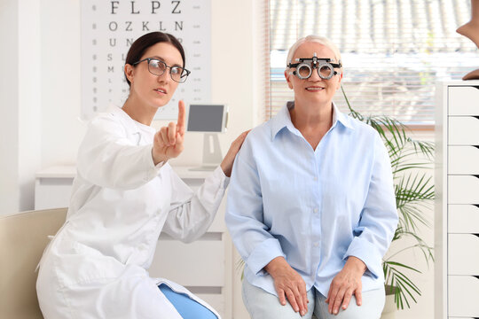 Eye care and vision health, optometrist examining senior womans eyesight with phoropter in clinic