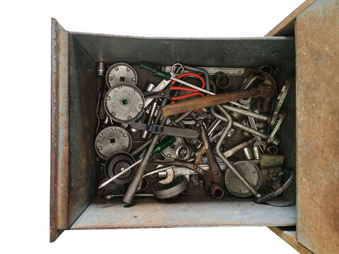 A steel drawer containing a disorganized set of tools.