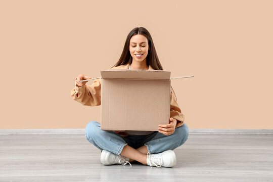 Online shopping and delivery, happy woman opening a cardboard box with a new purchase, unboxing experience at home