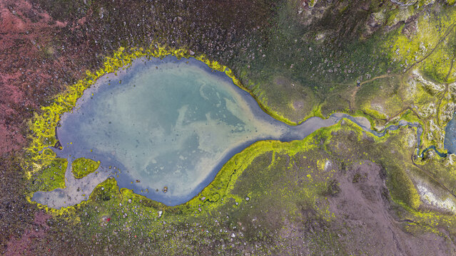 Aerial view of the Raudibotn crater lake surrounded by vibrant green moss and volcanic terrain in Svartafellstangi, Skaftarhreppur, Iceland.