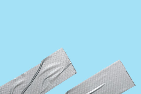 Duct tape strips on a light blue background, repair and temporary fix concept, adhesive material for quick solutions
