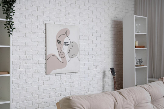 Beautiful interior of living room with shelving units and picture on white brick wall