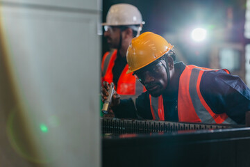 Fototapeta premium Technicians inspecting auto parts at liquid-filled station in auto parts factory