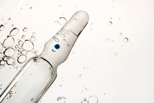 Clear ampoule containing liquid with air bubbles, representing science and medicine