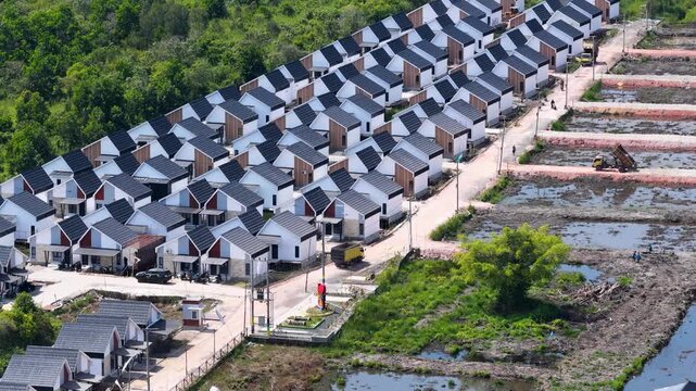 Rows of new houses being built in a suburban development area during a bright sunny day