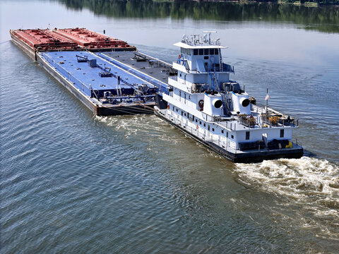 tugboat navigating South down the Mississippi river pushing a set of liquid cargo barges