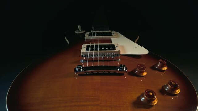 Close up cinematic shot of electric guitar bridge and pickups with sunburst finish.