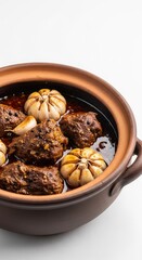 Fototapeta premium Traditional meat stew slow cooked in an earthen clay pot with whole garlic bulbs, dark aromatic spices, oil, and a rich coarse grain texture, clay pot, culinary, cooking
