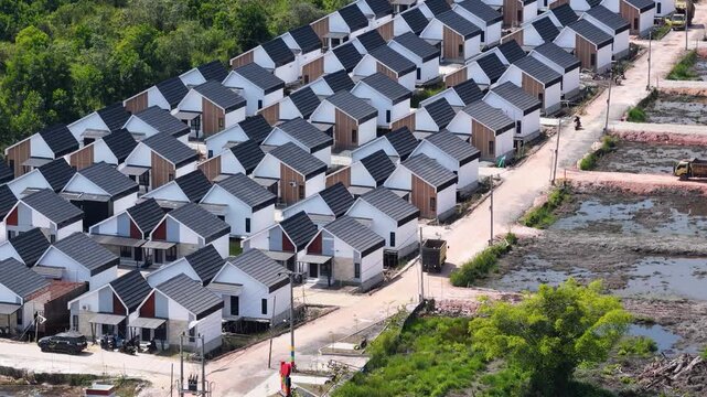 Rows of white houses with dark roofs surrounded by tropical greenery in South Kalimantan Indonesia
