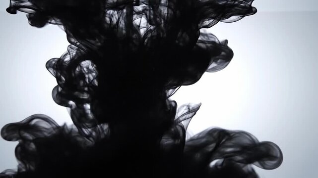 Abstract black ink swirling in water with soft light background artistic fluid motion