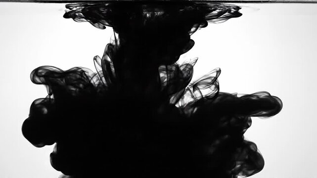 Black ink swirling in water with abstract shapes and smooth fluid motion on white background