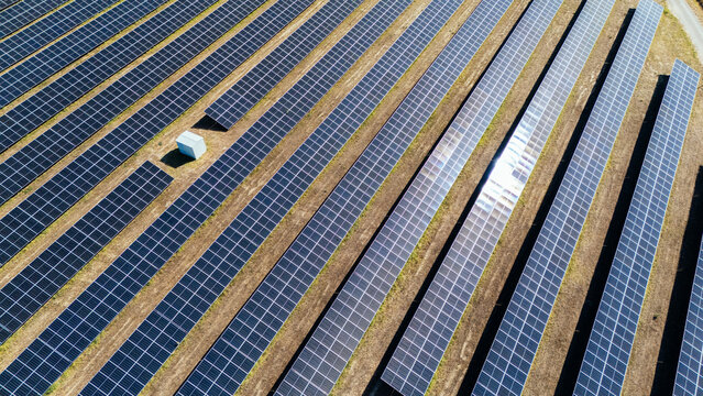 Aerial view of a large solar farm with rows of photovoltaic panels arranged on dry ground in Indjija, Vojvodina, Serbia.