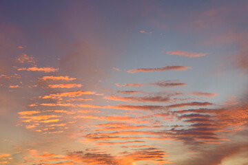 Fototapeta premium Golden orange and yellow sunset clouds on blue sky background.