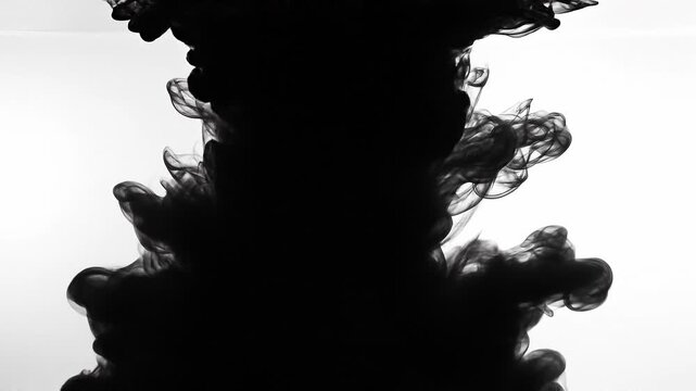 Black ink swirling in water creating abstract smoke patterns on white background