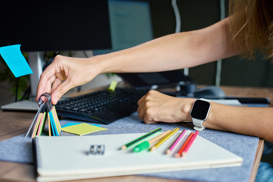Woman organizing pencils and stationery on her home office desk