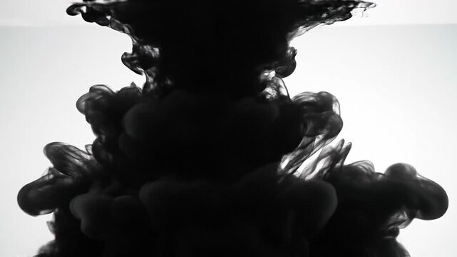 Abstract black ink swirling in water with white background artistic fluid motion