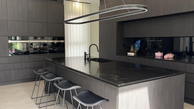 Modern Kitchen Interior with Large Island and Sculptural Pendant Lighting