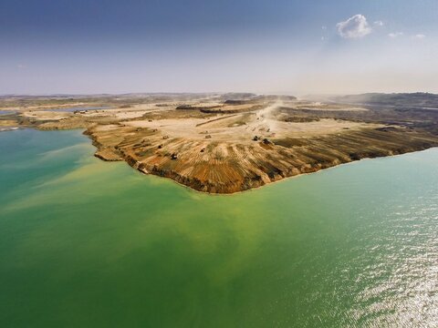 Aerial view of seafilling operations for Istanbul Airport construction with heavy machinery moving earth along the coastline in Istanbul, Turkey.