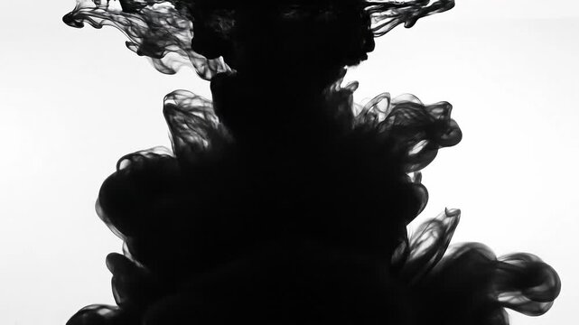 Black ink swirling in water with abstract smoke effect and fluid motion on white background