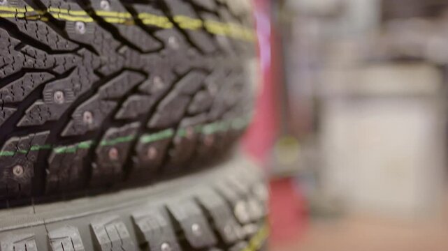 New winter tires with metal studs stacked for vehicle maintenance in professional car service workshop.